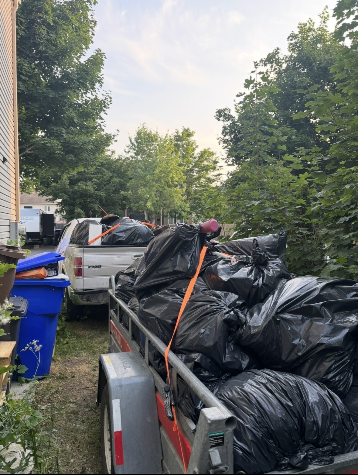 Pickup et trailer chargés de sacs lors d'un désencombrement